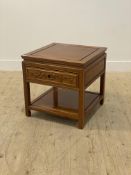 A Chinese hardwood lamp table, the panelled top over single drawer, raised on square supports united