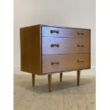 Stag, a mid century light oak veneered chest fitted with three drawers, raised on turned supports