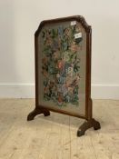 An early 20th century walnut fire screen with embroidered panel worked in a floral design, H68cm