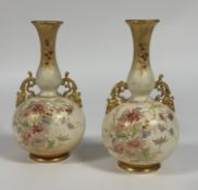 A pair of Royal Bonn German blush ivory bud vases with gilt and floral enameling and c-scroll gilt