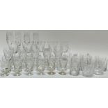 A large group of cut crystal drinking glasses comprising four champagne flutes (h- 23.5cm), five