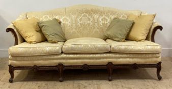 An early 20th century camel back sofa of Georgian design, upholstered in gilt floral damask