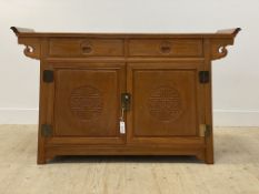A Chinese hardwood alter style cabinet, the panelled top above two drawers and two cupboards, raised