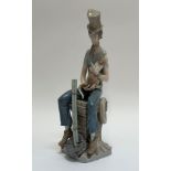 A Lladro figure of a man wearing a top hat sitting on top of a chimney holding a cat (crack and