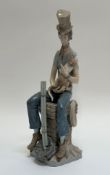 A Lladro figure of a man wearing a top hat sitting on top of a chimney holding a cat (crack and