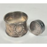 A modern silver circular pill box, (D x 3cm) and a Birmingham silver napkin ring, marks rubbed, (
