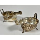 A pair of Sheffield silver scalloped sauce boats with C scroll handles raised on pad feet, (H x5cm x