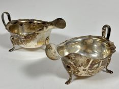 A pair of Sheffield silver scalloped sauce boats with C scroll handles raised on pad feet, (H x5cm x