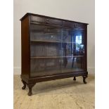 A mahogany bookcase, with two drawers over two glazed doors enclosing two shelves, raised on