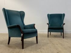 Parker Knoll, a pair of wingback armchairs, upholstered in teal velvet, raised on stained beech