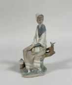 A Lladro figure of a Shepard lady sitting on a trunk looking at a bird. (h- 25.5cm) (no signs of