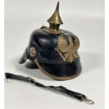 A good quality reproduction unused WWI child's Picklelaub helmet with brass fittings and leather