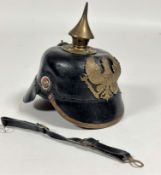 A good quality reproduction unused WWI child's Picklelaub helmet with brass fittings and leather