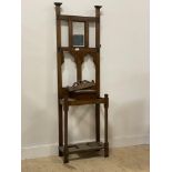 An early 20th century oak mirror back hall stand, fitted with four hooks and a glove box, (lacking
