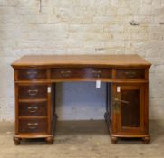 A Varnished pine desk of serpentine outline, fitted with three frieze drawers over three short
