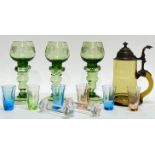 A mixed group of coloured glass comprising three green engraved blown glass stemmed cups/goblets (h-