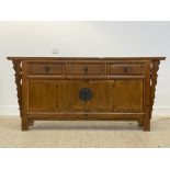 A Chinese hardwood sideboard, fitted with three drawers over bi-fold cupboards, raised on stile