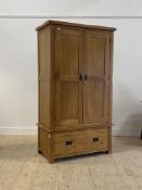 An oak two door wardrobe with interior fitted for hanging, over a drawer to base H147cm, W109cm,