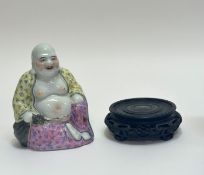 A Chinese happy buddha seated figure with a pink and yellow robe with floral decoration (marked