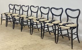 A set of seven Victorian ebonised dining chairs, with open kidney backs over upholstered seats and