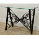 A contemporary console table, the glass top raised on a cast and wrought metal base of abstract form
