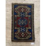 A small Turkish rug, the blue field centred by lozenge and within a border 96cm x 56cm