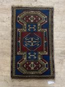 A small Turkish rug, the blue field centred by lozenge and within a border 96cm x 56cm