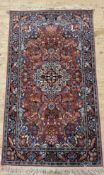 A Persian style rug, possibly Indian, with a busy pale red field and bird motif to border 174cm x