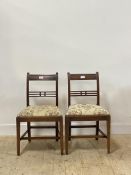 A pair of George III mahogany side chairs, each with rail back over drop in upholstered seat pads,