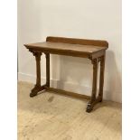 A Victorian Gothic revival oak side table, with ledge back above tracery corbels and square