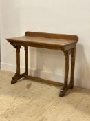 A Victorian Gothic revival oak side table, with ledge back above tracery corbels and square