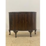 A mahogany bow front cabinet of 18th century design, the top with moulded edge over twin doors