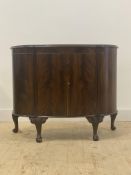A mahogany bow front cabinet of 18th century design, the top with moulded edge over twin doors