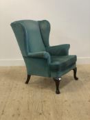 Parker Knoll, a wingback chair, upholstered in teal velvet, raised on cabriole supports H98cm,