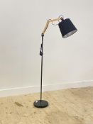 A Contemporary lamp standard, the articulated bulb raised on an aluminium post and circular base.