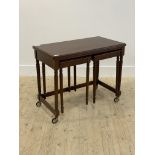 A mahogany metamorphic nest of tables, the fold over revolving top over two end tables raised on