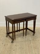 A mahogany metamorphic nest of tables, the fold over revolving top over two end tables raised on