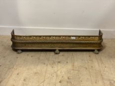 A 19th century pierced brass fire curb, standing on cast lion paw supports H23cm, W123cm