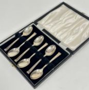A set of six Sheffield silver Art Deco style tea spoons with scroll terminals complete with fitted