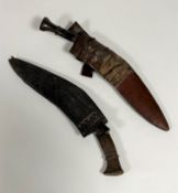 Two early 20thc. Nepalese kukris, one with horn handle, missing, one small knife in leather scabbard