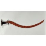 An Ethiopian shotel, 20thc., hardwood handle with curved steel blade and leather scabbard (87cm)