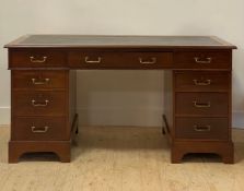 An Edwardian walnut twin pedestal desk, the top inset with tooled skiver writing surface above three