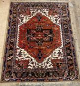 A Persian Heriz hand knotted carpet, with medallions and spandrels and all over geometric floral