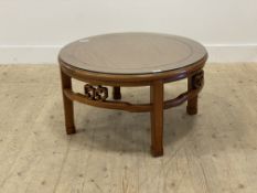 A Chinese hardwood circular coffee table, the plate glass top over open carved fret frieze. raised