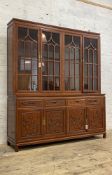 A large Chinese hardwood bookcase on cupboard, fitted with four tracery glazed doors enclosing