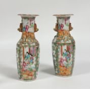A pair of late Qing Canton baluster vases decorated with figures in interior scenes in famille