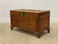 A Chinese hardwood blanket box, the top and panelled front carved with birds and blossom trees,