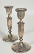 A pair of Birmingham silver baluster candle sticks raised on circular stepped weighted bases, (H x