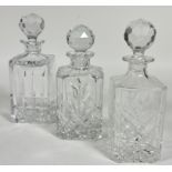 A group of three crystal square cut Whisky decanters with faceted ball pattern stoppers.( 2 x H 26cm