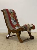 A Victorian walnut framed nursing chair, with scrolling show fame and supports enclosing an